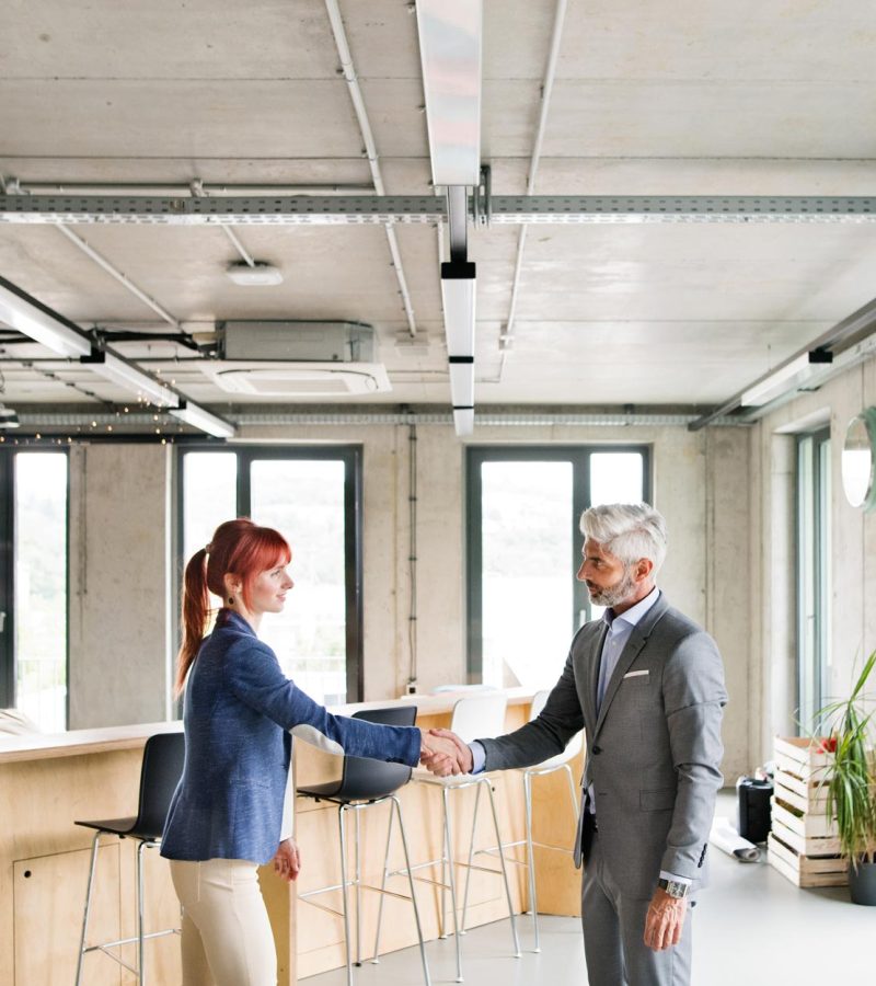 two-business-people-in-the-office-shaking-hands-PWRS4YC.jpg